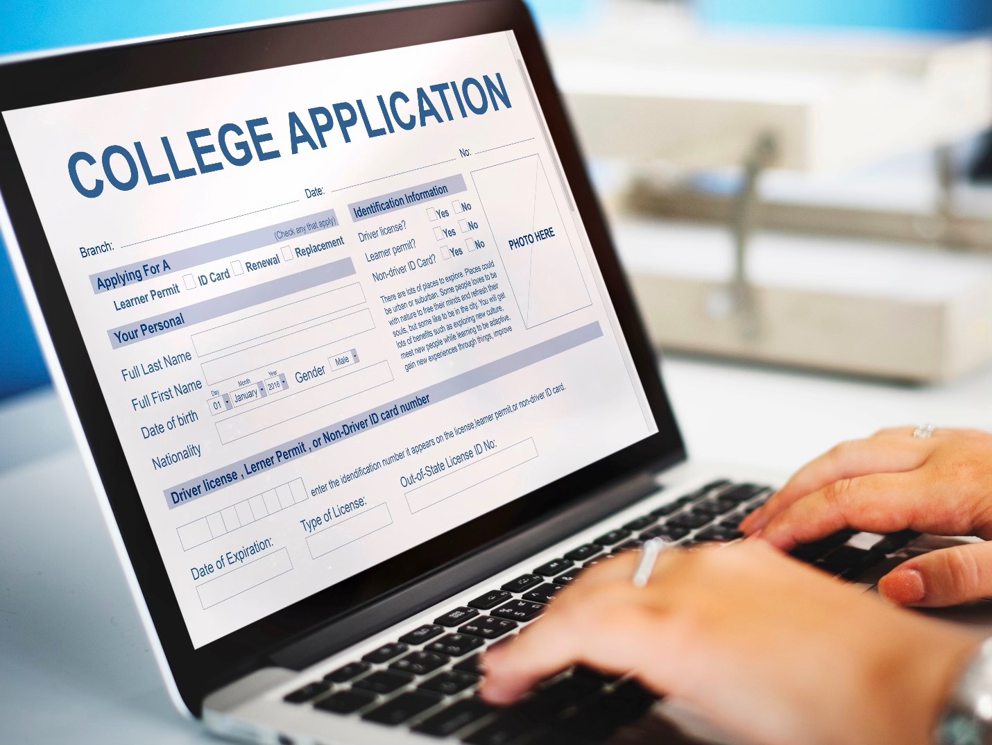 A student filling out a college application on a laptop